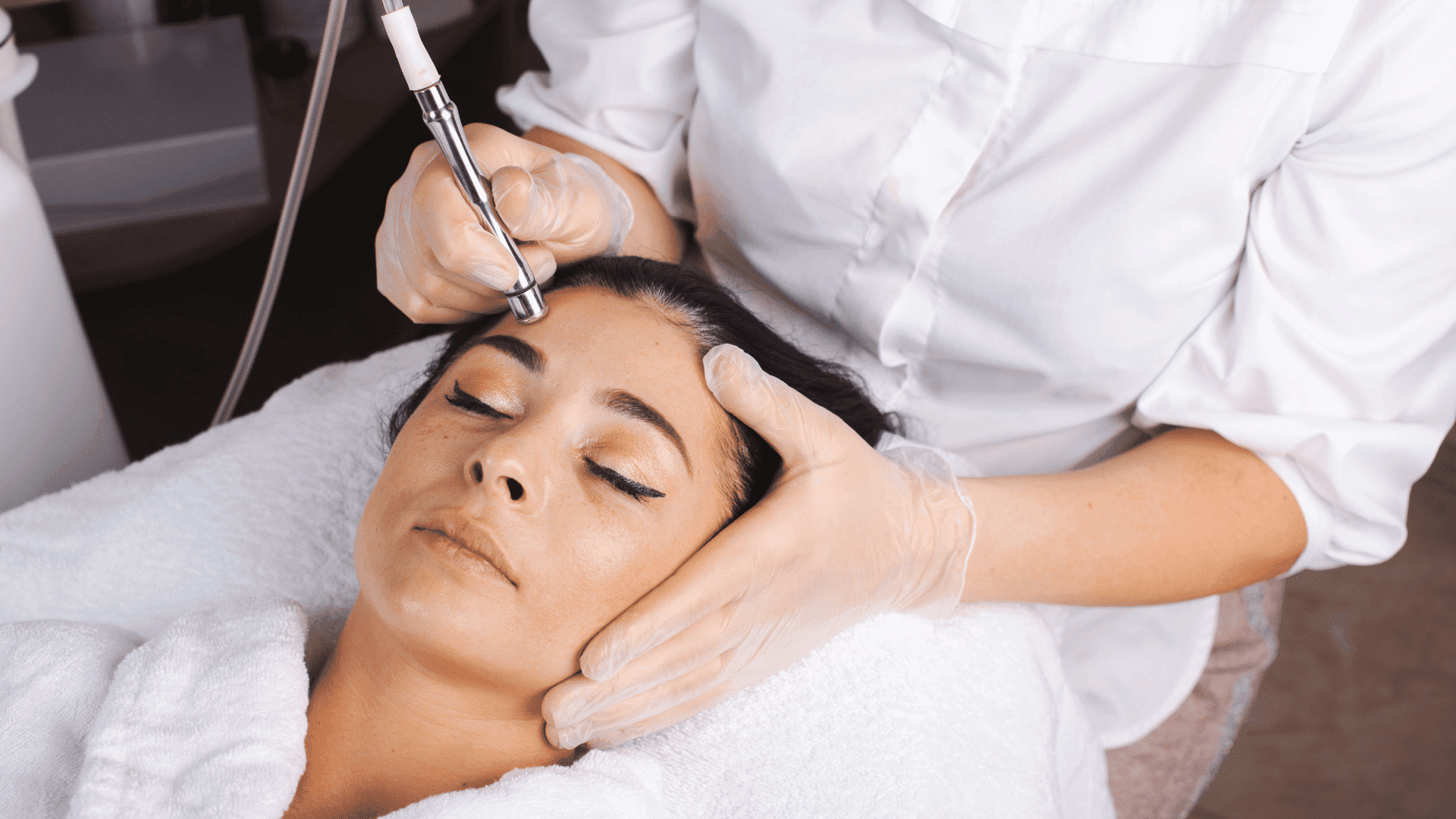 Woman receiving a facial treatment with advanced skincare equipment.